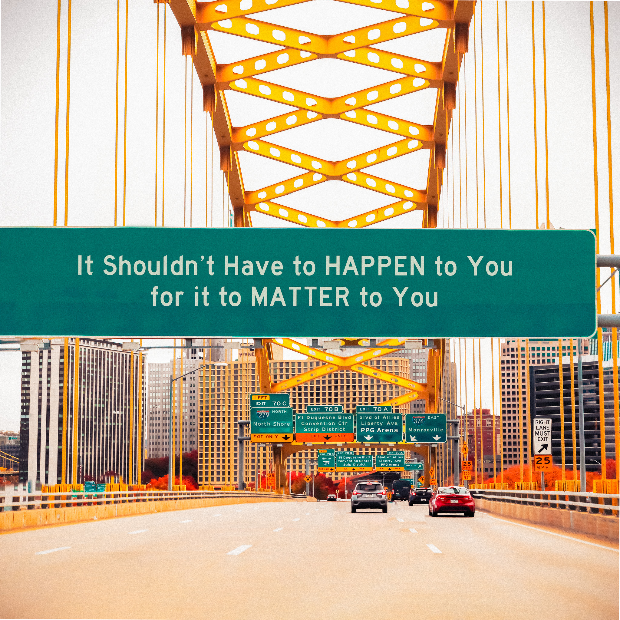 Road sign leading into the city of Pittsburgh that reads "It shouldn't have to happen to you for it to matter to you."